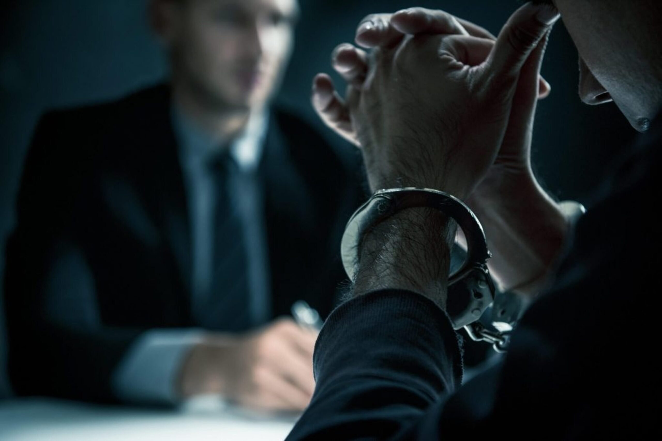 Handschellen bei einer Befragung im Büro | KANZLEI:KREMERS